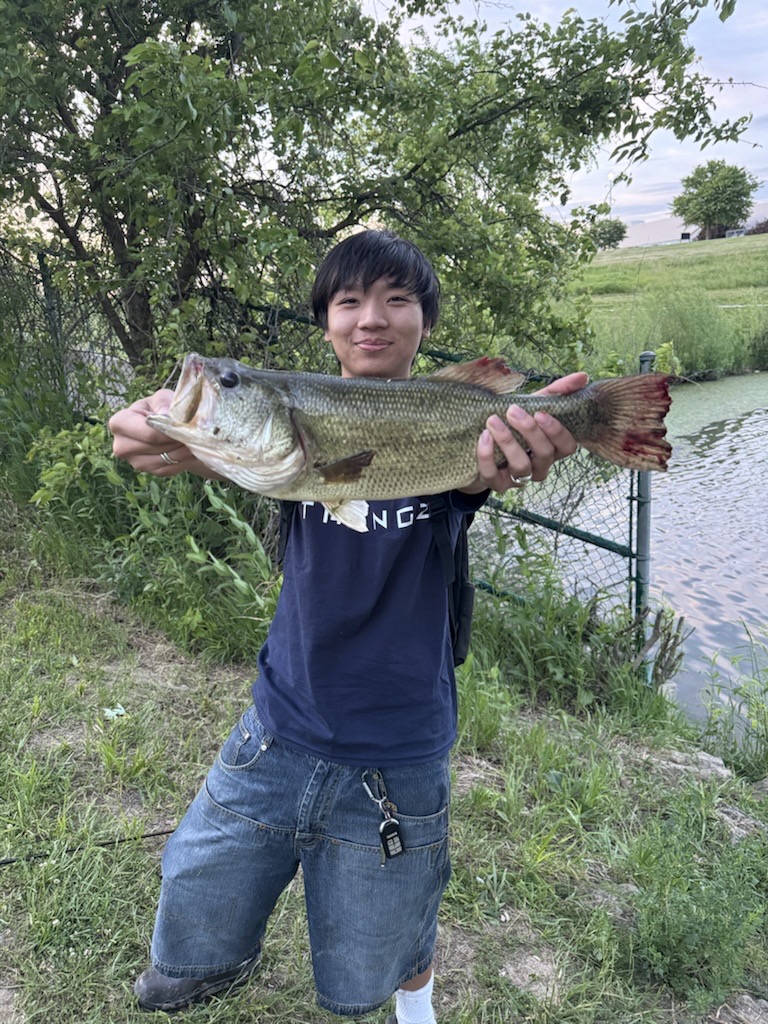 Holding a largemouth bass near the water